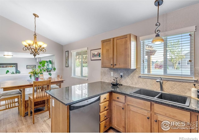 kitchen featuring dishwasher, a sink, light wood finished floors, lofted ceiling, and decorative backsplash