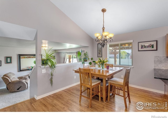 dining area featuring a chandelier, wood finished floors, vaulted ceiling, and baseboards