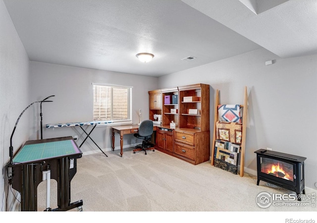office space with light colored carpet, baseboards, and a textured ceiling