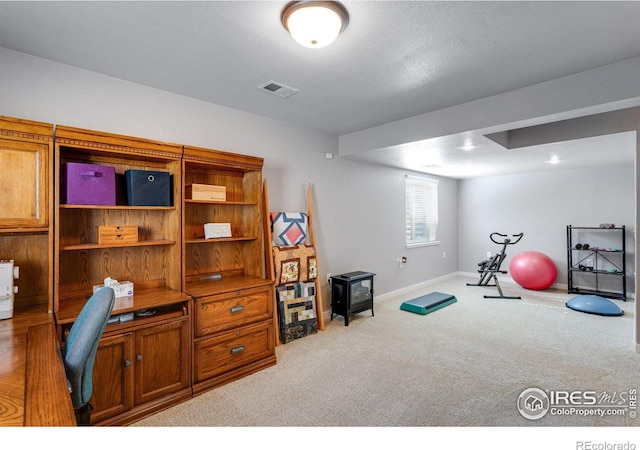 exercise room with carpet and baseboards