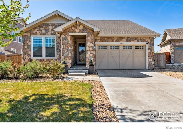 view of front of house featuring stone siding, an attached garage, and concrete driveway