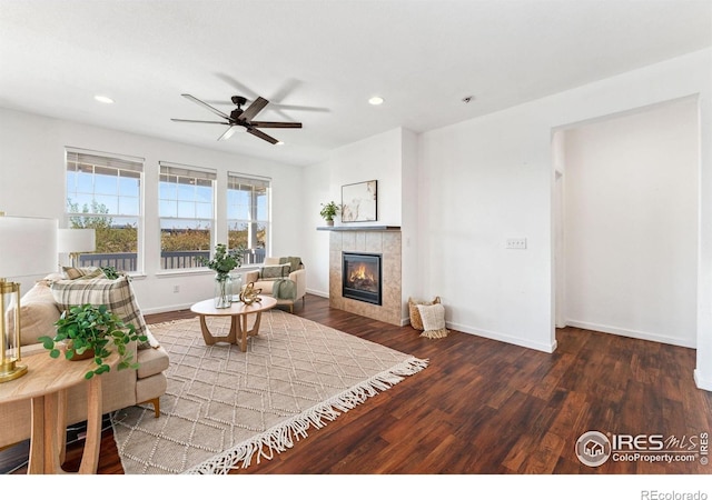 living room featuring ceiling fan, a tile fireplace, wood finished floors, recessed lighting, and baseboards