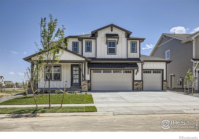 1679 Crystalline Dr, Windsor, CO 80550 - view of front facade featuring board and batten siding, concrete driveway, a garage, and covered porch