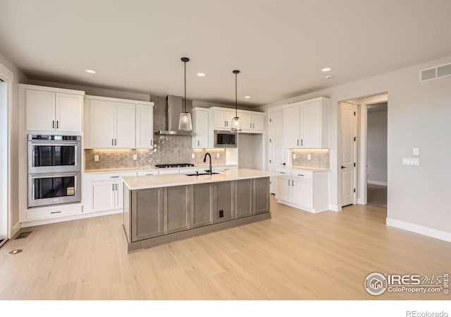 1679 Crystalline Dr, Windsor, CO 80550 - kitchen with wall chimney exhaust hood, appliances with stainless steel finishes, a sink, light wood finished floors, and recessed lighting