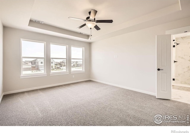 1679 Crystalline Dr, Windsor, CO 80550 - spare room featuring a raised ceiling, carpet flooring, ceiling fan, and baseboards