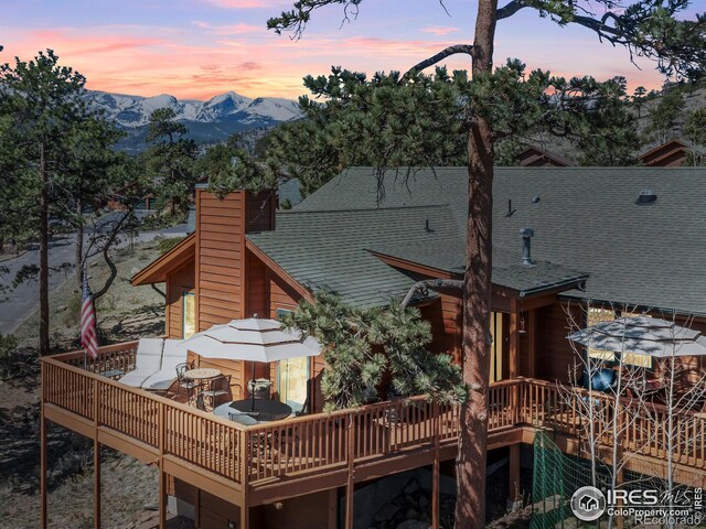658 Cedar Ridge Cir, Estes Park, CO 80517 - rear view of property featuring a deck with mountain view, a chimney, and a shingled roof