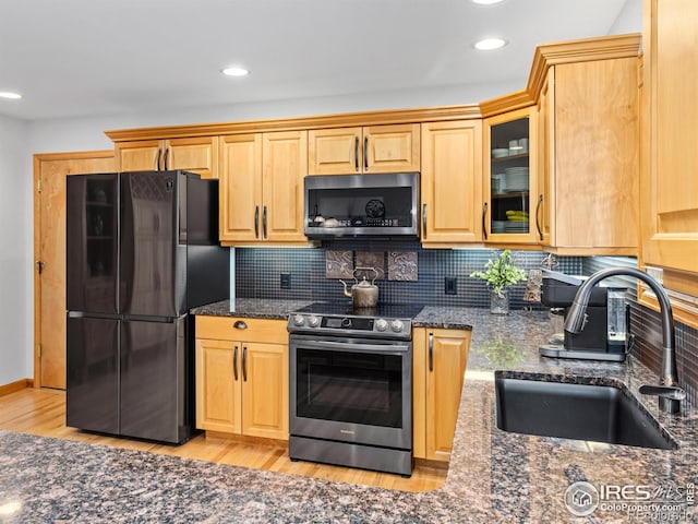 658 Cedar Ridge Cir, Estes Park, CO 80517 - kitchen featuring appliances with stainless steel finishes, a sink, light wood-style floors, dark stone counters, and recessed lighting