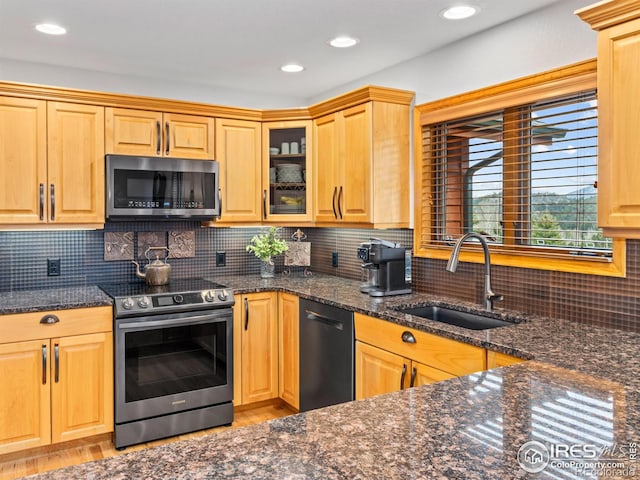 658 Cedar Ridge Cir, Estes Park, CO 80517 - kitchen featuring stainless steel appliances, a sink, light wood finished floors, dark stone counters, and backsplash