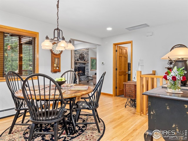 658 Cedar Ridge Cir, Estes Park, CO 80517 - dining space with light wood-type flooring, plenty of natural light, a stone fireplace, and recessed lighting