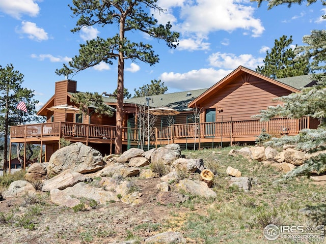 658 Cedar Ridge Cir, Estes Park, CO 80517 - rear view of property featuring a deck, a chimney, and roof with shingles