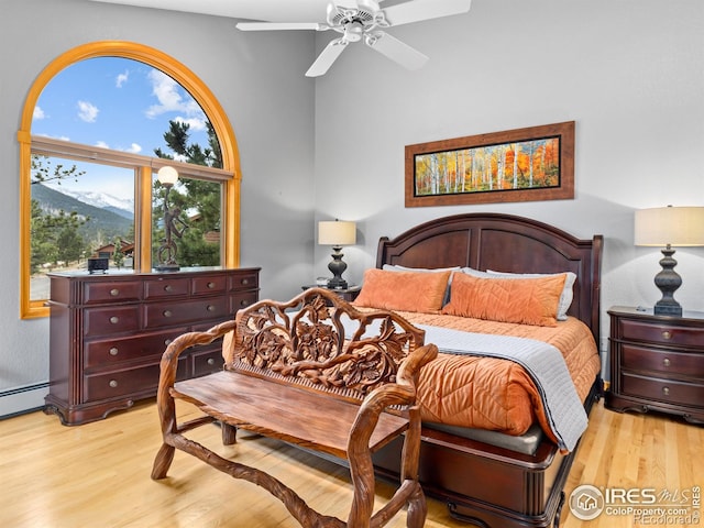 658 Cedar Ridge Cir, Estes Park, CO 80517 - bedroom with light wood-type flooring, ceiling fan, a mountain view, and baseboard heating