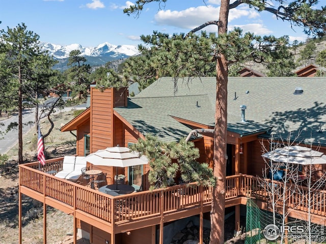 658 Cedar Ridge Cir, Estes Park, CO 80517 - rear view of property featuring a deck with mountain view, roof with shingles, and a chimney