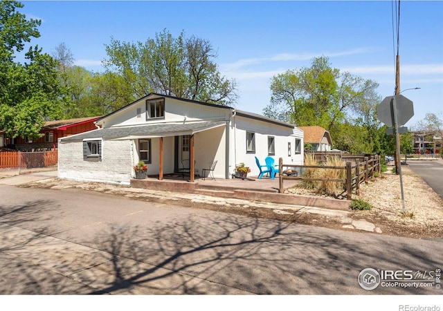 view of front of property featuring fence and covered porch