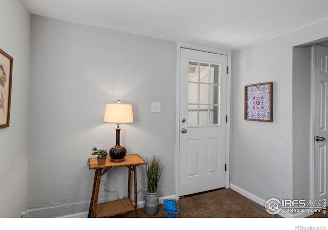 doorway with baseboards and carpet floors