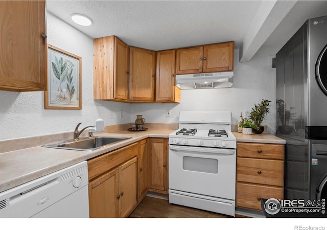 kitchen featuring white appliances, under cabinet range hood, a sink, light countertops, and a textured ceiling