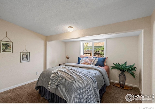 bedroom with carpet flooring, baseboards, and a textured ceiling