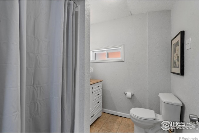 bathroom featuring toilet, vanity, tile patterned flooring, a shower with shower curtain, and baseboards