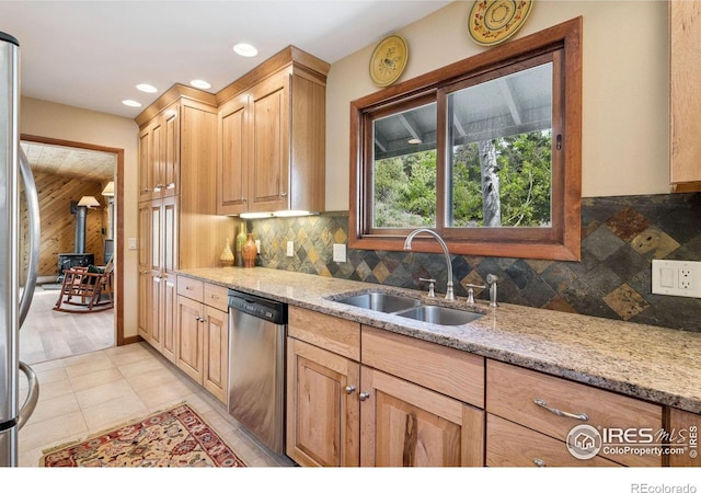 1433 Vista View Ln, Estes Park, CO 80517 - kitchen featuring stainless steel appliances, a sink, decorative backsplash, light stone counters, and wood walls
