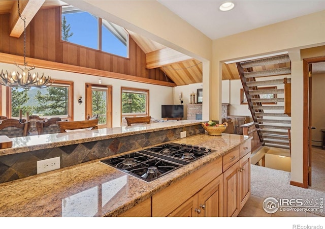 1433 Vista View Ln, Estes Park, CO 80517 - kitchen featuring black gas cooktop, light stone counters, light colored carpet, and a chandelier