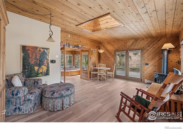 1433 Vista View Ln, Estes Park, CO 80517 - living room featuring wooden ceiling, healthy amount of natural light, a wood stove, wooden walls, and light wood-type flooring