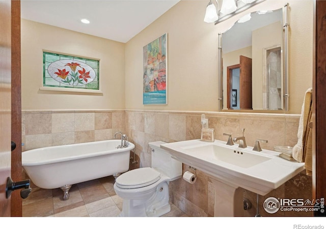 1433 Vista View Ln, Estes Park, CO 80517 - full bath with tile walls, a soaking tub, a sink, a wainscoted wall, and toilet