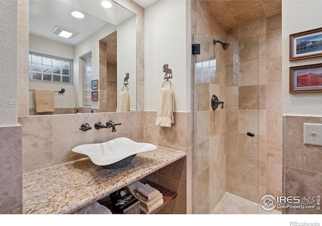1433 Vista View Ln, Estes Park, CO 80517 - full bathroom featuring a tile shower, a sink, tile walls, and recessed lighting