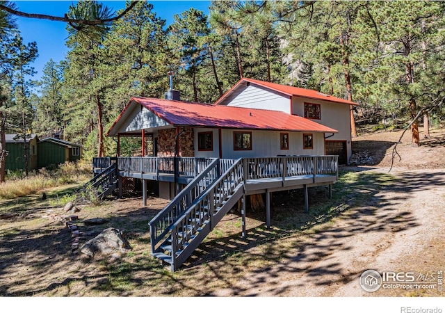 31 Cedar Dr, Lyons, CO 80540 - rustic home featuring stairs, metal roof, driveway, an attached garage, and a wooden deck