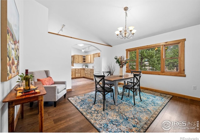 31 Cedar Dr, Lyons, CO 80540 - dining space with dark wood finished floors, vaulted ceiling, arched walkways, a chandelier, and baseboards