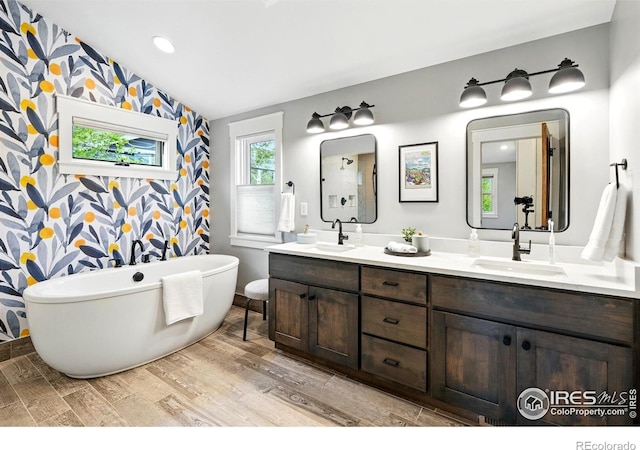 3059 6th St, Boulder, CO 80304 - full bath with wood finished floors, vaulted ceiling, double vanity, a freestanding bath, and an accent wall