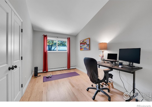 office space with wood finished floors, a baseboard heating unit, lofted ceiling, and baseboards