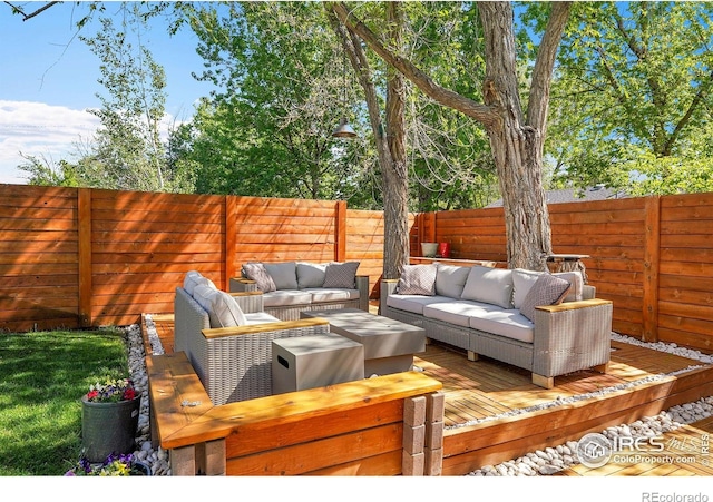 wooden deck with an outdoor hangout area and a fenced backyard