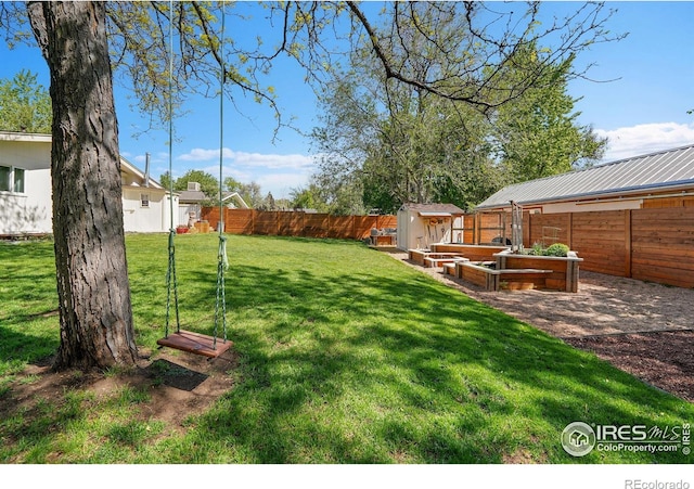 view of yard with a storage shed, an outdoor structure, and a garden