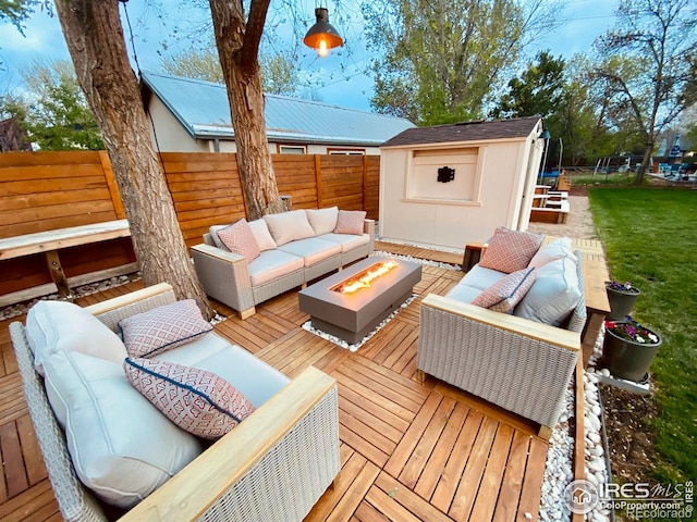 deck with an outdoor living space with a fire pit, a storage shed, and an outdoor structure