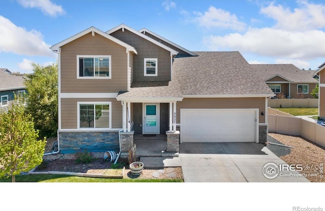 craftsman inspired home with stone siding, fence, driveway, a shingled roof, and an attached garage