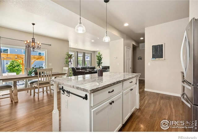 kitchen featuring freestanding refrigerator, dark wood finished floors, a chandelier, white cabinetry, and baseboards