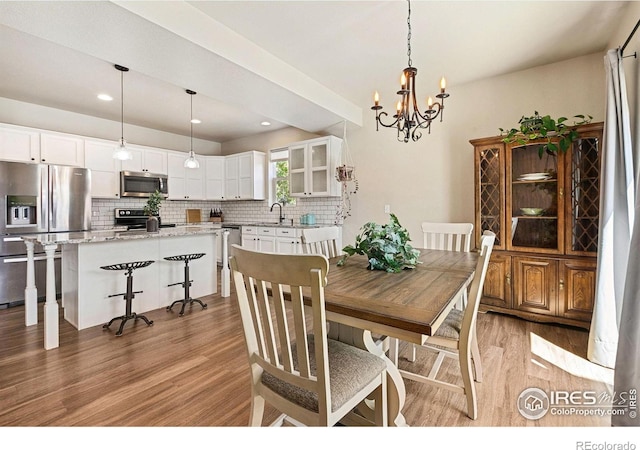 dining room with light wood-type flooring, a chandelier, and recessed lighting