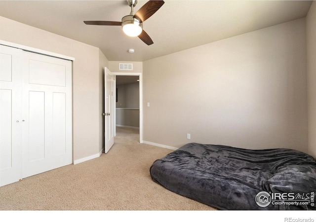 carpeted bedroom with baseboards, ceiling fan, and a closet