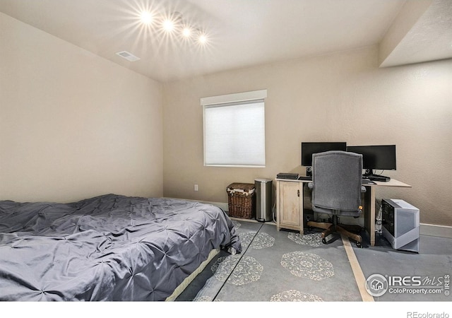 bedroom with light colored carpet, baseboards, and a desk
