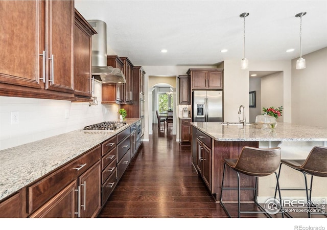 2150 Blue Yonder Way, Fort Collins, CO 80525 - kitchen featuring appliances with stainless steel finishes, ventilation hood, arched walkways, a sink, and dark wood-type flooring