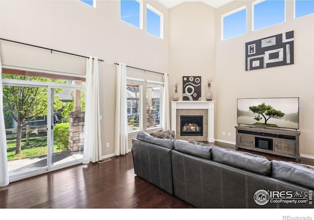 2150 Blue Yonder Way, Fort Collins, CO 80525 - living area featuring a fireplace, dark wood-style floors, plenty of natural light, baseboards, and a towering ceiling
