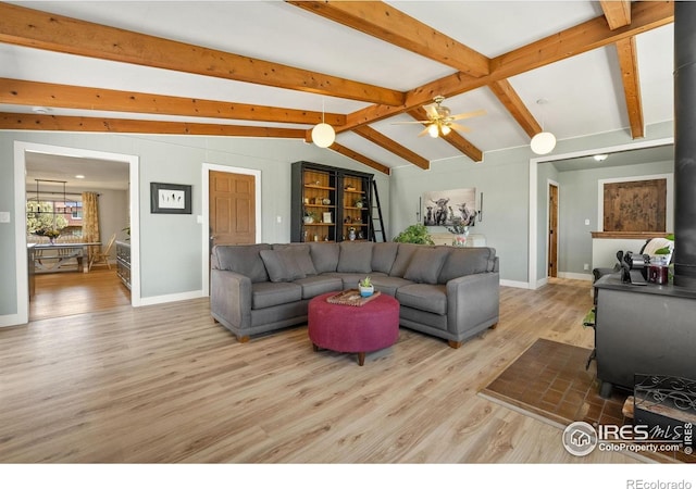 living area featuring wood finished floors, baseboards, and a ceiling fan