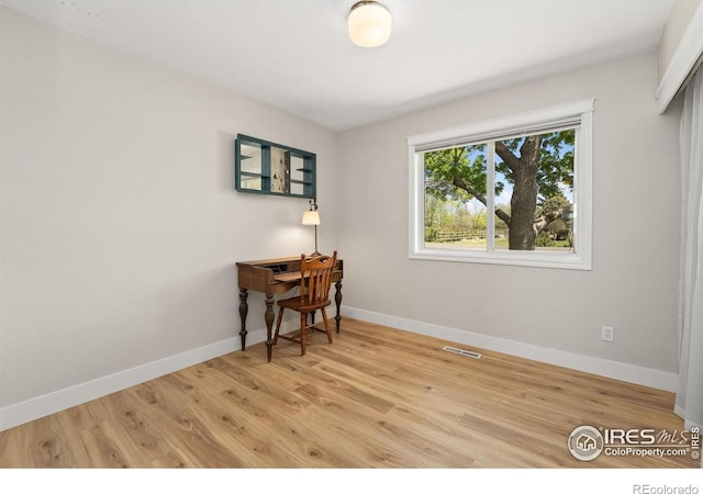 office space featuring baseboards and light wood-type flooring