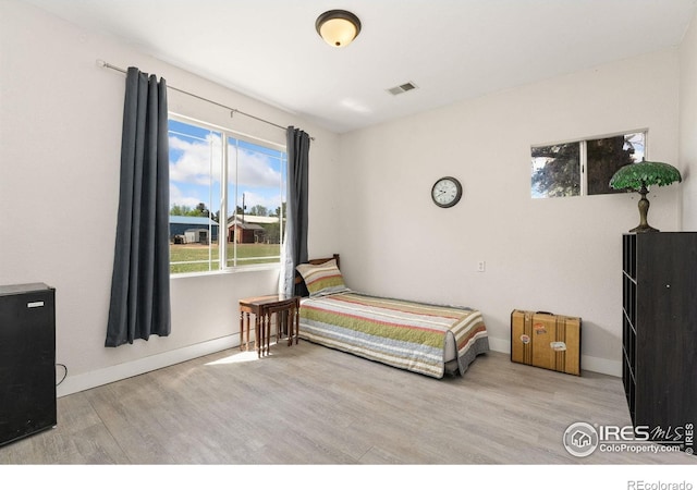 bedroom with wood finished floors and baseboards