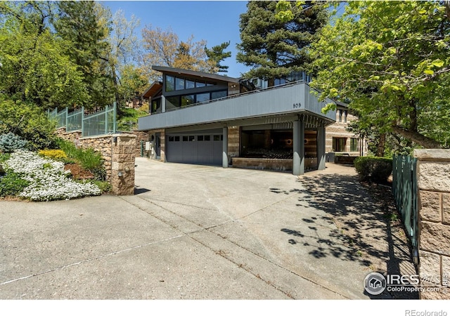 505 Geneva Ave, Boulder, CO 80302 - view of property exterior featuring driveway, an attached garage, stone siding, and a balcony