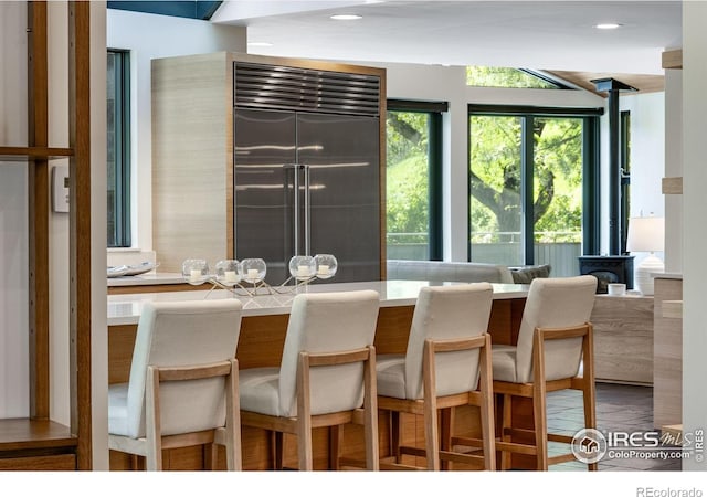 505 Geneva Ave, Boulder, CO 80302 - kitchen featuring stainless steel built in refrigerator, a kitchen breakfast bar, recessed lighting, a wood stove, and light countertops