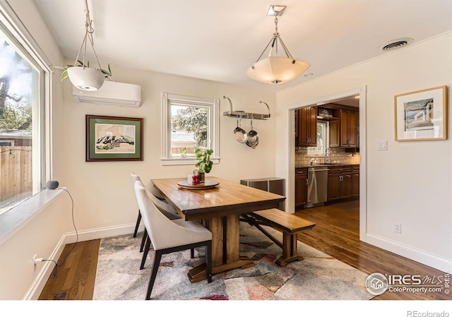 1136 Venice St, Longmont, CO 80501 - dining space with a wall mounted AC, dark wood-style flooring, and baseboards