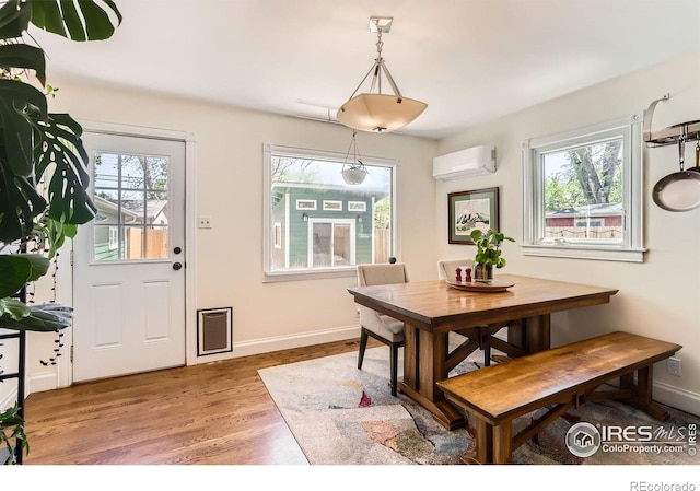 1136 Venice St, Longmont, CO 80501 - dining room featuring a wall mounted air conditioner, wood finished floors, and baseboards