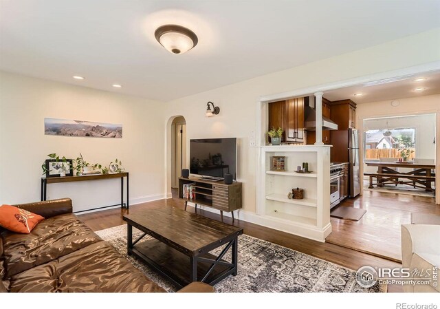 1136 Venice St, Longmont, CO 80501 - living area featuring arched walkways, wood finished floors, recessed lighting, and baseboards