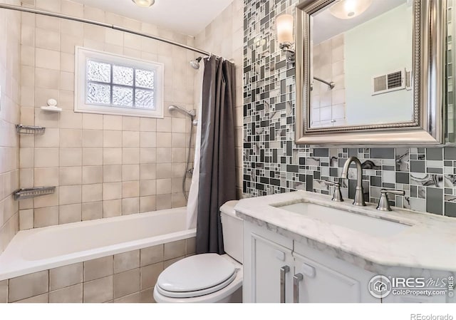 1136 Venice St, Longmont, CO 80501 - full bathroom featuring tiled shower / bath combo, toilet, decorative backsplash, vanity, and tile walls