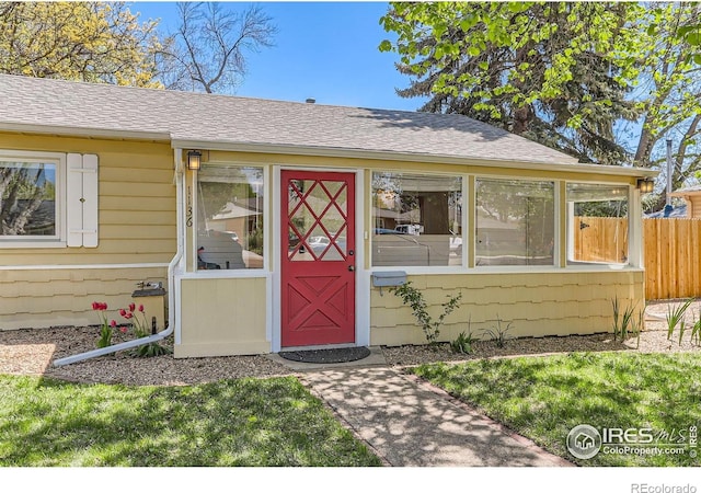 1136 Venice St, Longmont, CO 80501 - doorway to property featuring roof with shingles and fence